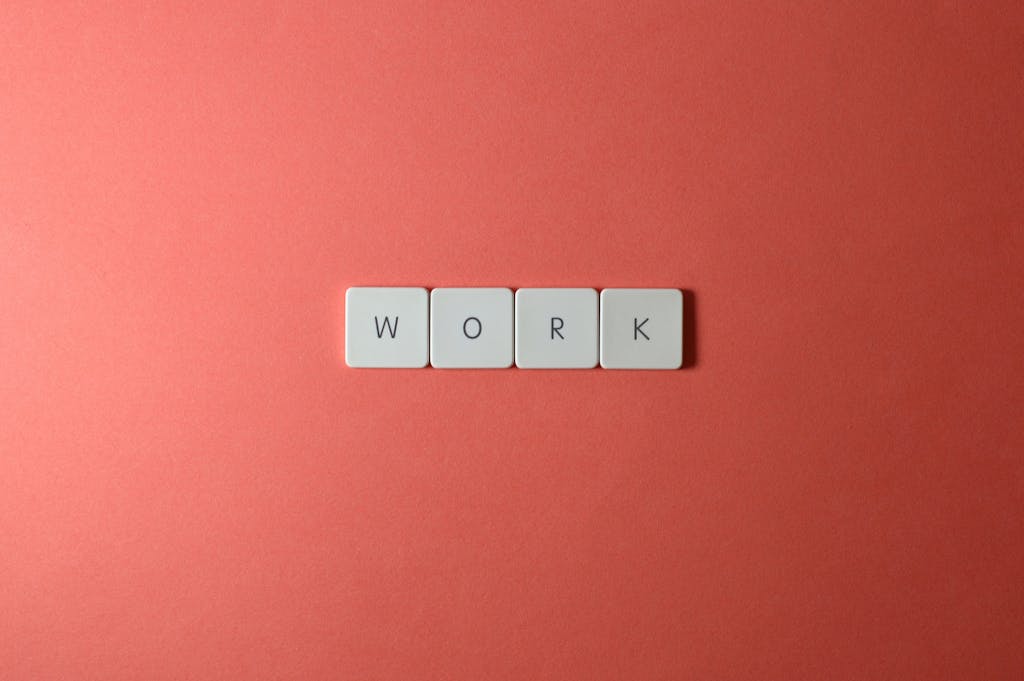 Minimalist image featuring the word 'work' with keyboard keys on a coral background. Perfect for workplace or business themes.